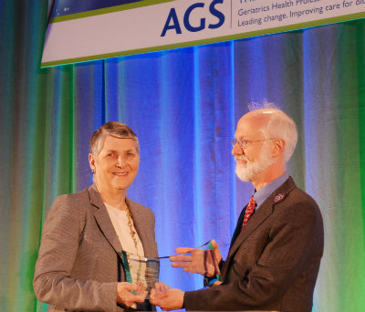 Dr. Corinne H. Rieder, left, accepts the David H. Solomon Memorial Public Service Award from AGS President Dr. Wayne McCormick.