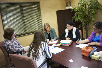 From left, Jane Dohrmann, Mercedes Bern-Klug, and Nicole Peterson meet with staff at Lantern Park Nursing & Rehab Center to help them understand how best to use the IPOST form.